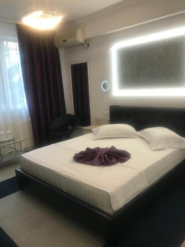 a bedroom with a large bed with a robe on it at Hotel Bulevard Prestige in Slatina