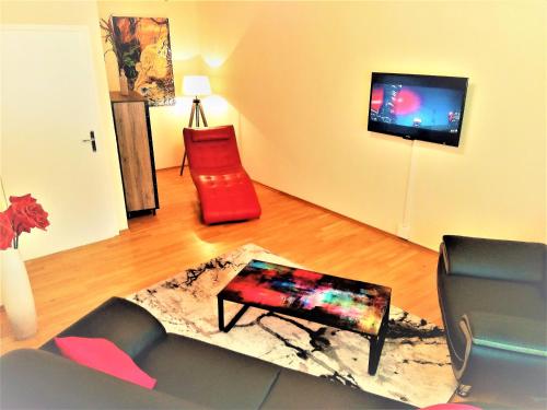 un soggiorno con divano e sedia rossa di Apartment Hof-Bayern a Hof
