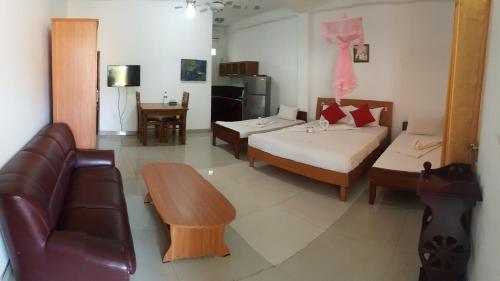 ein Wohnzimmer mit 2 Betten und einem Sofa in der Unterkunft Shanith Guesthouse Negombo in Negombo