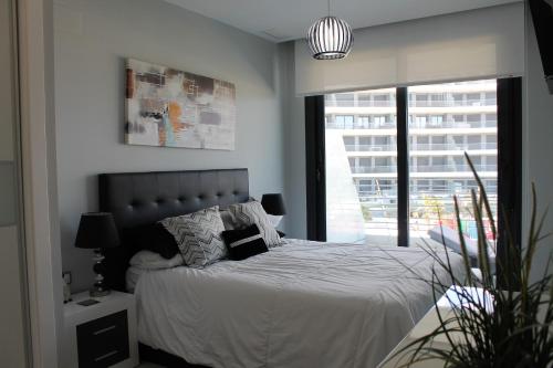 - une chambre avec un lit doté de draps blancs et une fenêtre dans l'établissement Infinity View Lovely Apartment, à Arenales del Sol