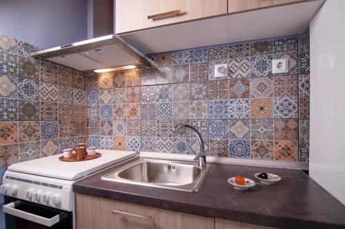 a kitchen with a sink and a stove at Velpina Apartments in Potamiá