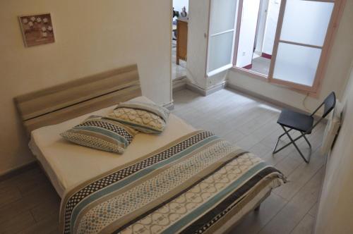 Saint-Amand-en-PuisayeにあるPetite maison aux volets bleusのベッド1台(枕2つ、椅子付)