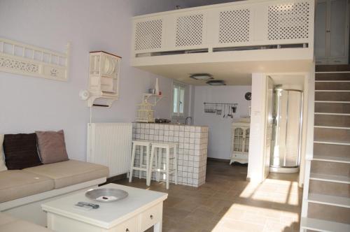 salon z kanapą i łóżkiem na podwyższeniu w obiekcie Crisio Studios w mieście Skiros