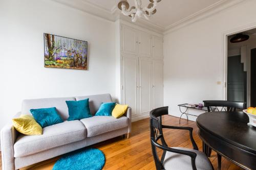 un salon avec un canapé et une table dans l'établissement Veeve - Cosy Gambetta, à Paris