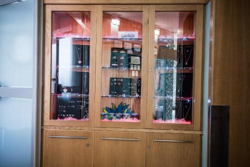a wooden cabinet with glass doors with a bunch of glasses at First Group La Cote D'Azur in Margate