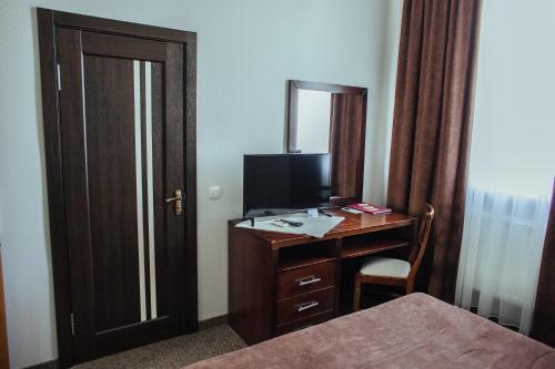 a bedroom with a desk with a computer and a mirror at JJ Hotel in Vynohradiv