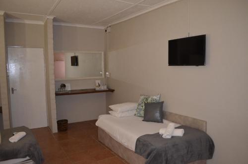 a hotel room with a bed and a flat screen tv at Mariental Hotel Cc in Mariental