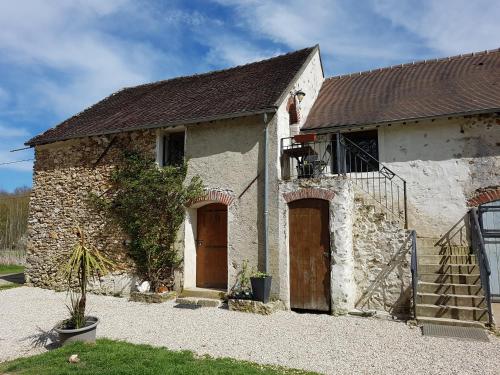 an old stone building with two brown doors at La Montagne de Bellot in Bellot