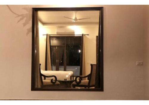 a mirror on a wall with a table and a chair at Riverside Resort in Lap of Nature in Nainital