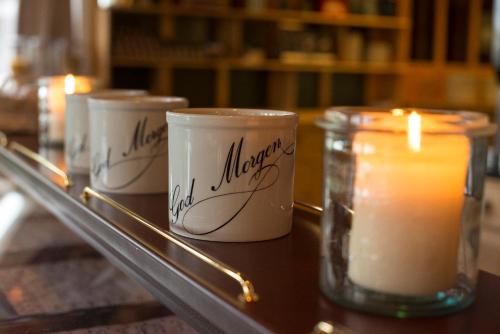 three candles sitting on a table with a candle at Trolltun Hotel & Hytter in Dombås