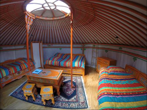 um quarto com duas camas e uma mesa numa tenda em Yourtes Olachat proche Annecy em Faverges