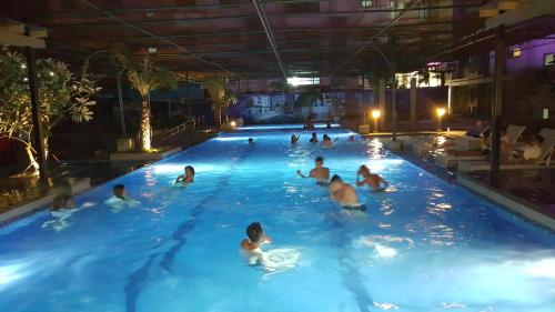 a group of people swimming in a swimming pool at Khalil's Horizons 101 Studio Type Condominium in Cebu City