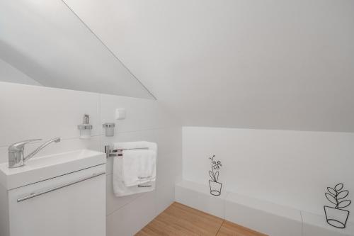 a white bathroom with a sink and a mirror at Apartamenty Gdańsk EU - Waterlane in Gdańsk