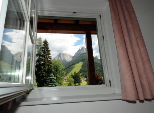 a window with a view of a mountain at Casa El Tobià in Pozza di Fassa