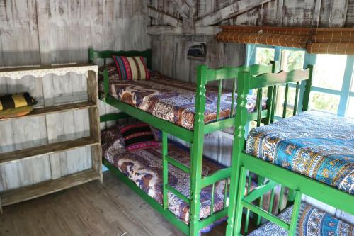 a room with two bunk beds and a couch at CasaHostel Floresce in Praia do Rosa
