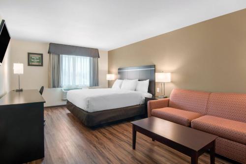 een hotelkamer met een bed en een bank bij Econo Lodge Inn & Suites in Springfield