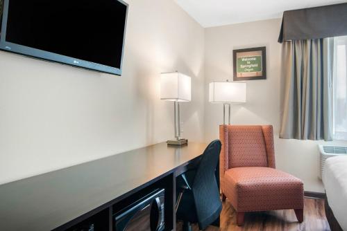 a hotel room with a desk with a tv and a chair at Econo Lodge Inn & Suites Springfield Main Street in Springfield
