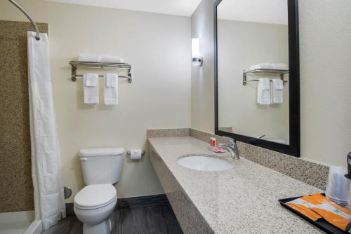 a bathroom with a toilet and a sink with a mirror at Econo Lodge Inn & Suites Springfield Main Street in Springfield