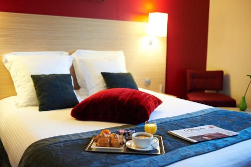 a tray of food sitting on top of a bed at Hotel Restaurant Du Parc Saumur Logis Elégance in Saumur