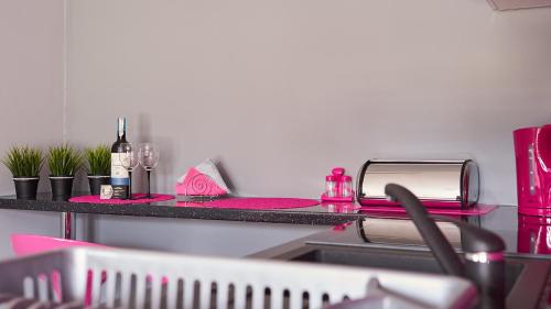 a kitchen counter with pink items on a counter top at Apartament Perła Pienin in Dębno