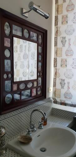a bathroom with a sink and a wall with clocks at B&B La Cascina Grossa in Alessandria