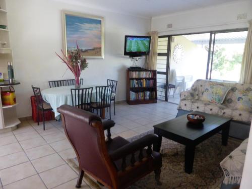 a living room with a couch and a table at Sole's Leap in Scottburgh