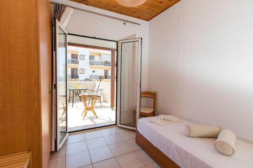 a bedroom with a bed and a balcony with a table at Apartments Barbie in Rethymno Town