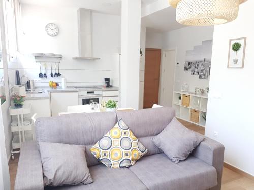 a living room with a couch and a kitchen at Apartamentos Los Corralejos in Fuengirola