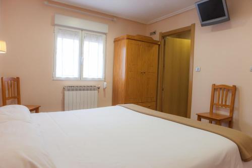 a bedroom with a large white bed and a window at Casa Rural Lagun Etxea in Pobes