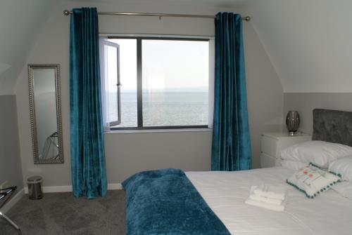 a bedroom with a bed and a large window at Watersedge Redcastle in Red Castle