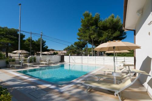 - une piscine avec des chaises et un parasol dans l'établissement B&B Nacorè, à Massafra