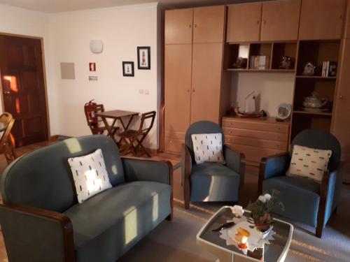 a living room with two chairs and a table at Casa Vista Mar Torreira in Torreira