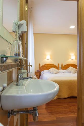 a bathroom with a sink and two beds at Casa Rural Lagun Etxea in Pobes