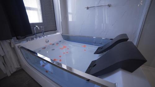 a bathroom with a tub with orange flowers in it at Hotel Royal - Beauty & Spa in Porto Cesareo