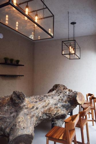 a room with a large tree branch and wooden chairs at Hotel Casa Andaria in San José Iturbide