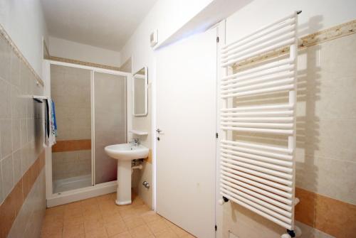 a white bathroom with a sink and a toilet at Appartamenti Serenity - 2 posti auto - in villa e in centro in Marina di Campo