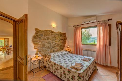 um quarto com uma cama e uma grande janela em La Villetta em Montaione