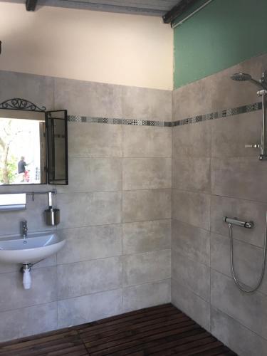 a bathroom with a sink and a shower at Spa Les Jardins De Chiron Lodges et Tiny House dans le sud in Sauve