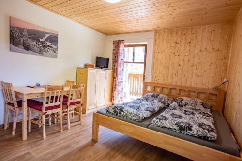 a bedroom with a bed and a table and a dining room at S4 Resort Kouty in Loučná nad Desnou