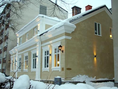 a white house with snow on the ground at Vandrarhem Uppsala Kungsängstorg in Uppsala