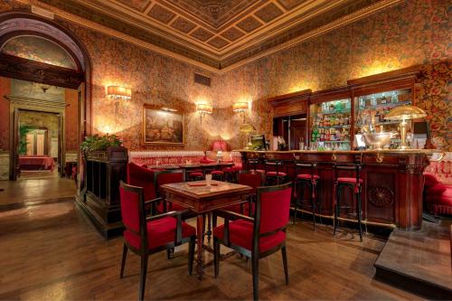 a bar with red chairs and a table in a room at Grand Hotel Plaza in Rome