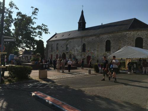 a crowd of people walking down a street near a church at L'abbatiale in Corbie