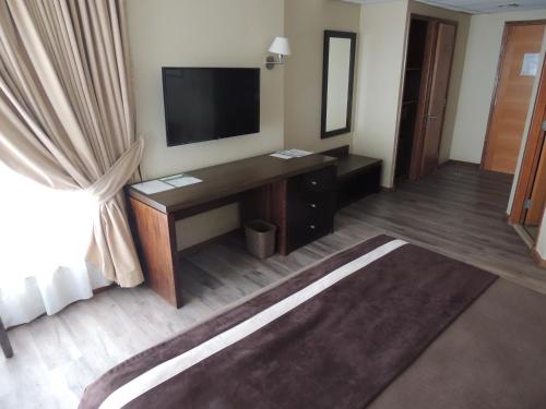 a hotel room with a television and a desk at Hotel Diego de Almagro Valparaíso in Valparaíso