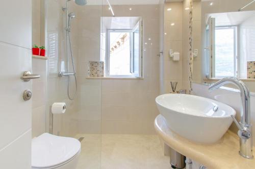 a bathroom with a sink and a toilet and a shower at Kanavelic place - Old town Korcula in Korčula