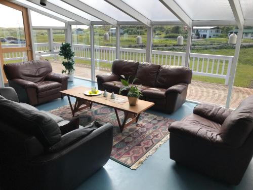 uma sala de estar com sofás de couro e uma mesa de centro em Helgafell Hostel em Djúpivogur