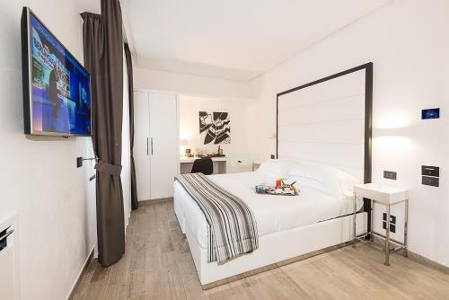 a bedroom with a white bed and a flat screen tv at LHP Hotel Santa Margherita Palace & SPA in Santa Margherita Ligure