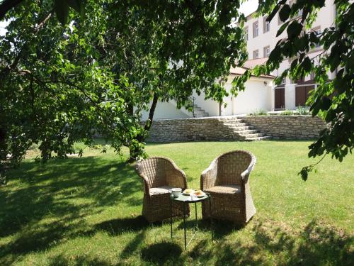 two chairs and a table in the grass at Villa Magdalena in Kutná Hora