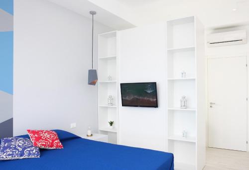 a bedroom with a blue bed and white shelves at Sea Windows Suite in Trapani