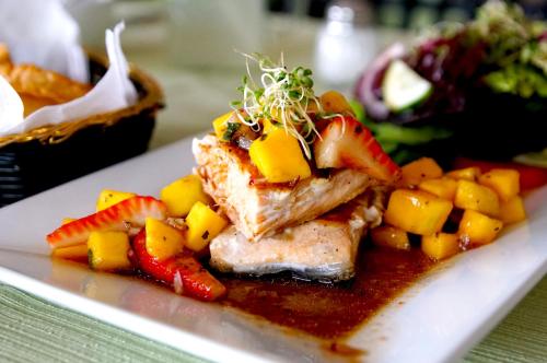 a plate of food with meat and fruit on it at Hotel Costa Brava in Manzanillo
