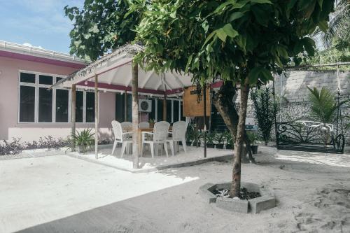 a table and chairs in front of a house at Azoush Tourist Guesthouse in Fulhadhoo